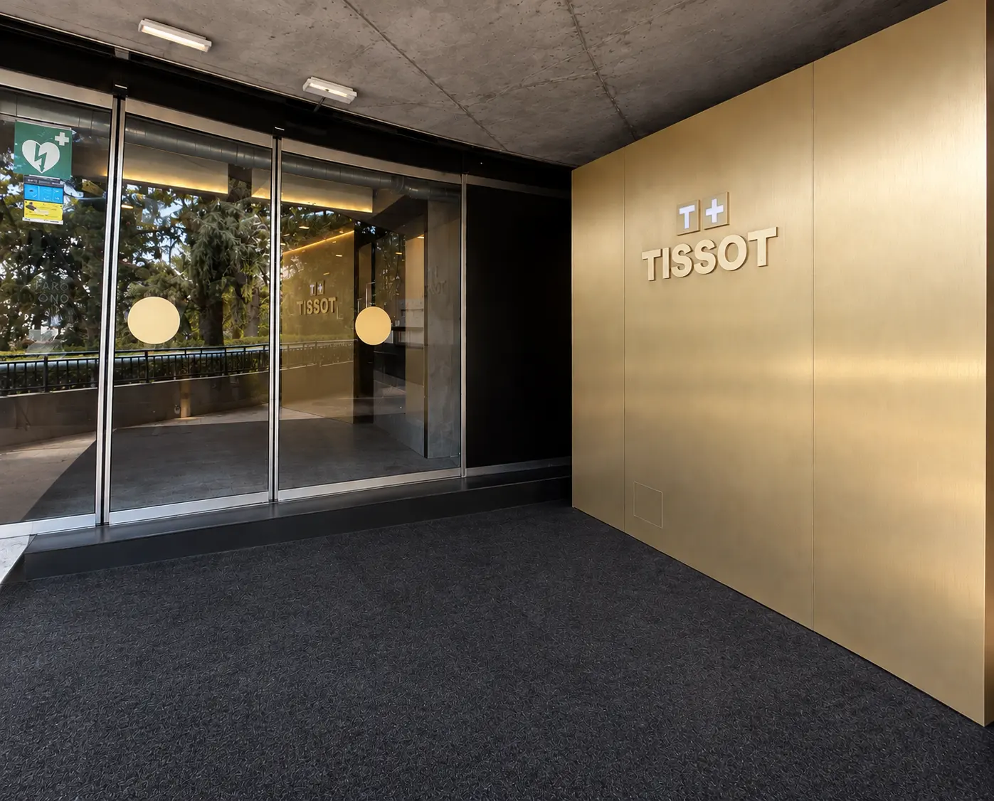 Acceso con logotipo de Tissot sobre pared dorada