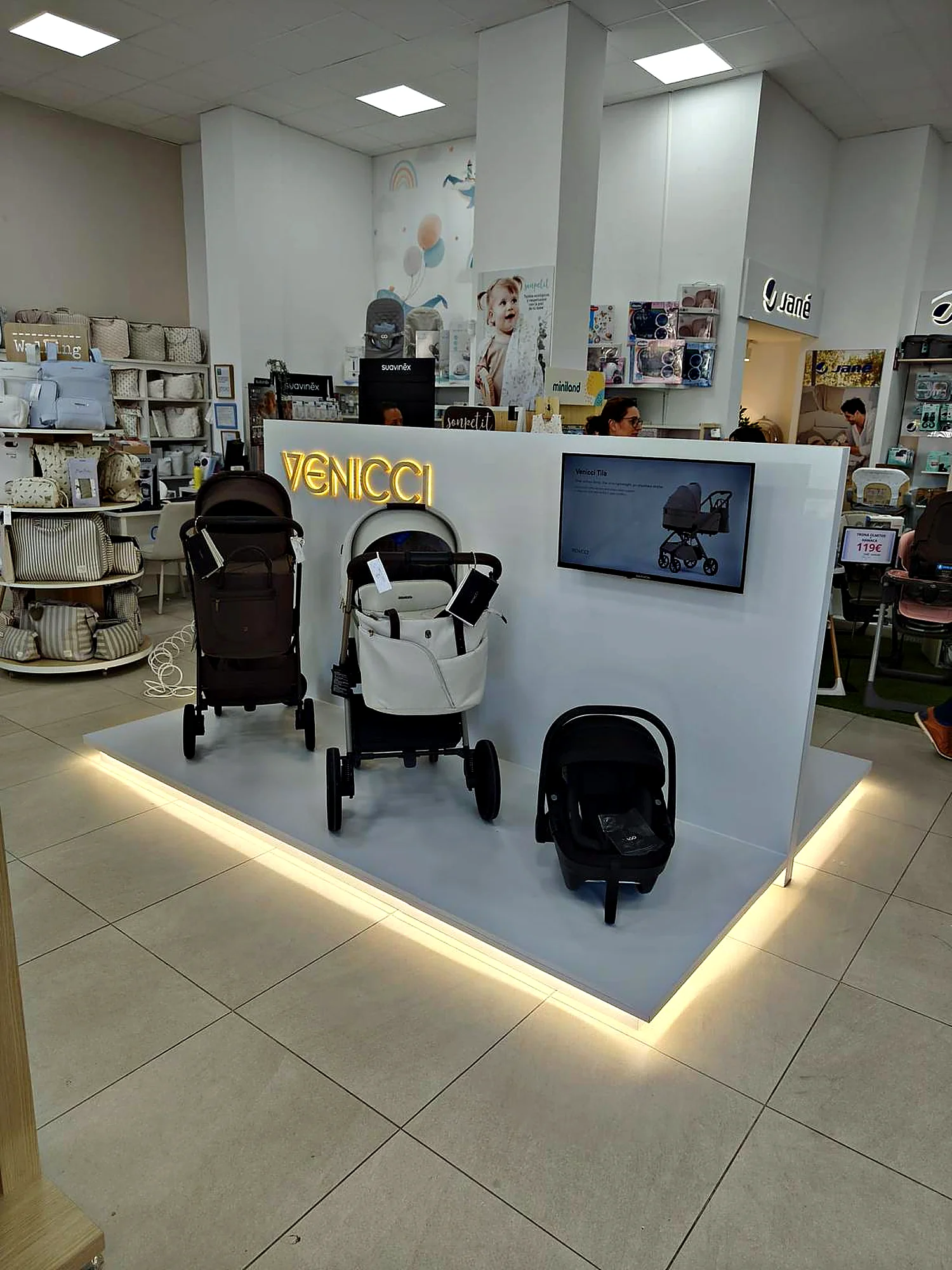 Córner blanco retroiluminado de Venicci con carritos de bebé en tienda